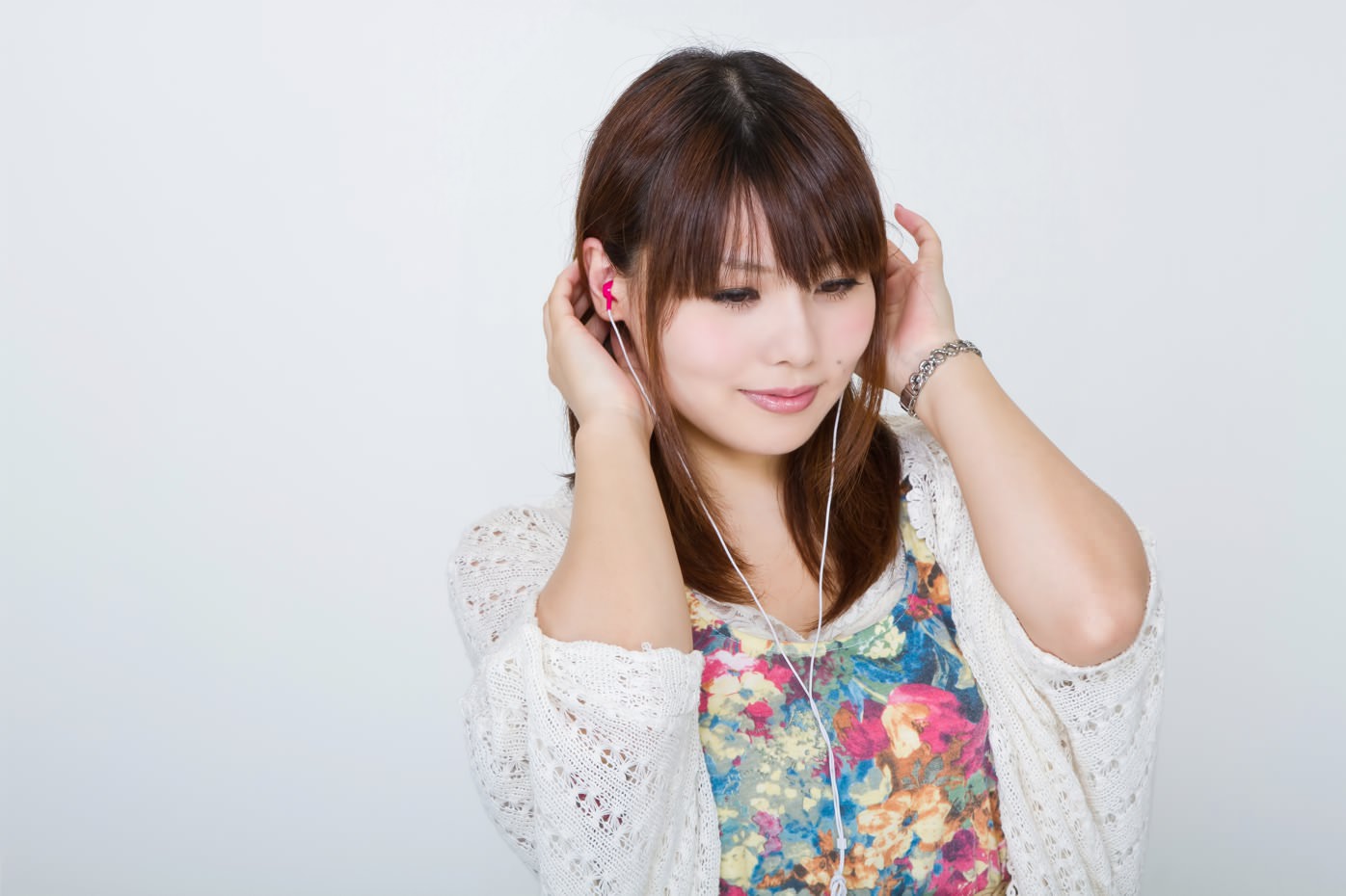 イヤホンで音楽を聴く女性。